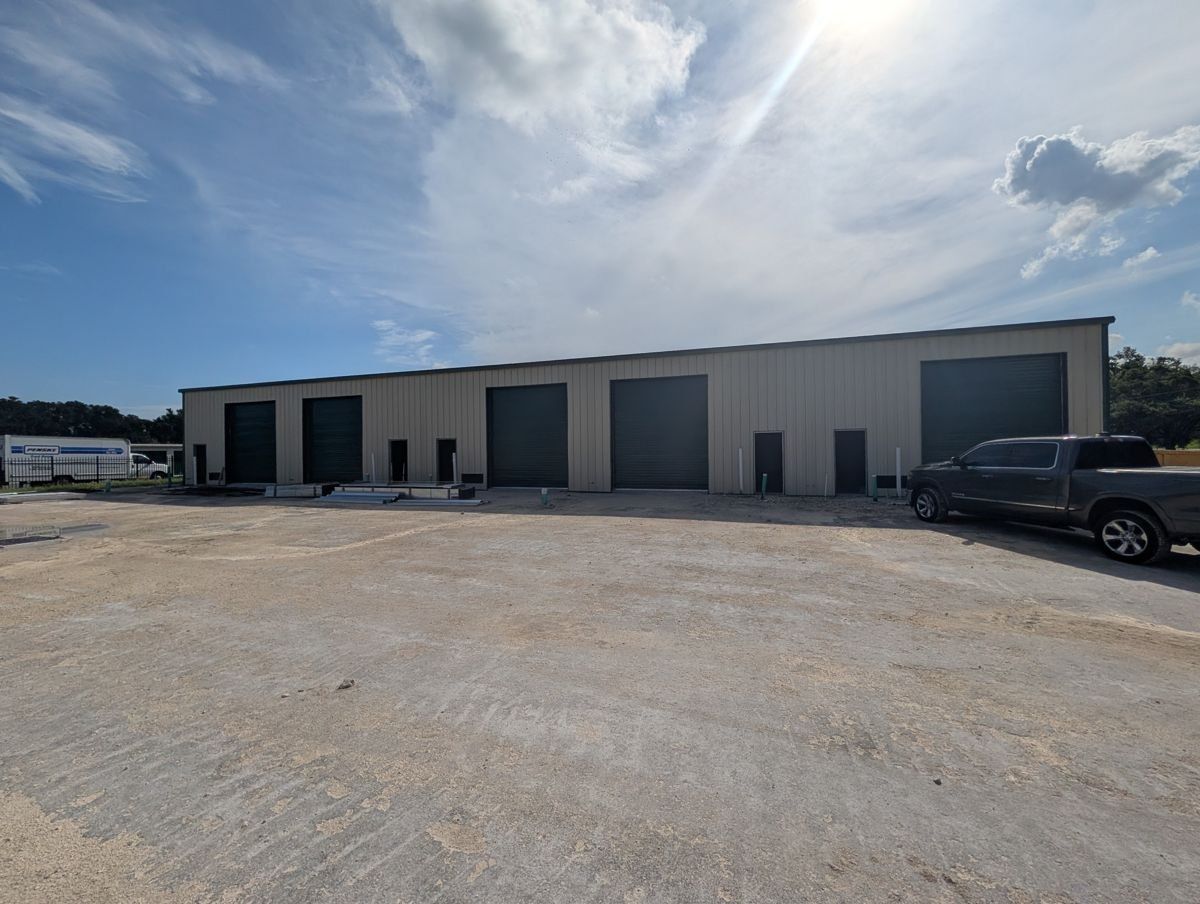 Flex building front with a row of overhead doors and parking.
